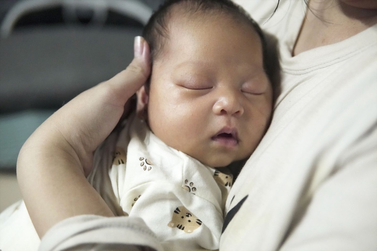 Bé được mẹ ôm ấp, vỗ về sau khi tiêm phòng