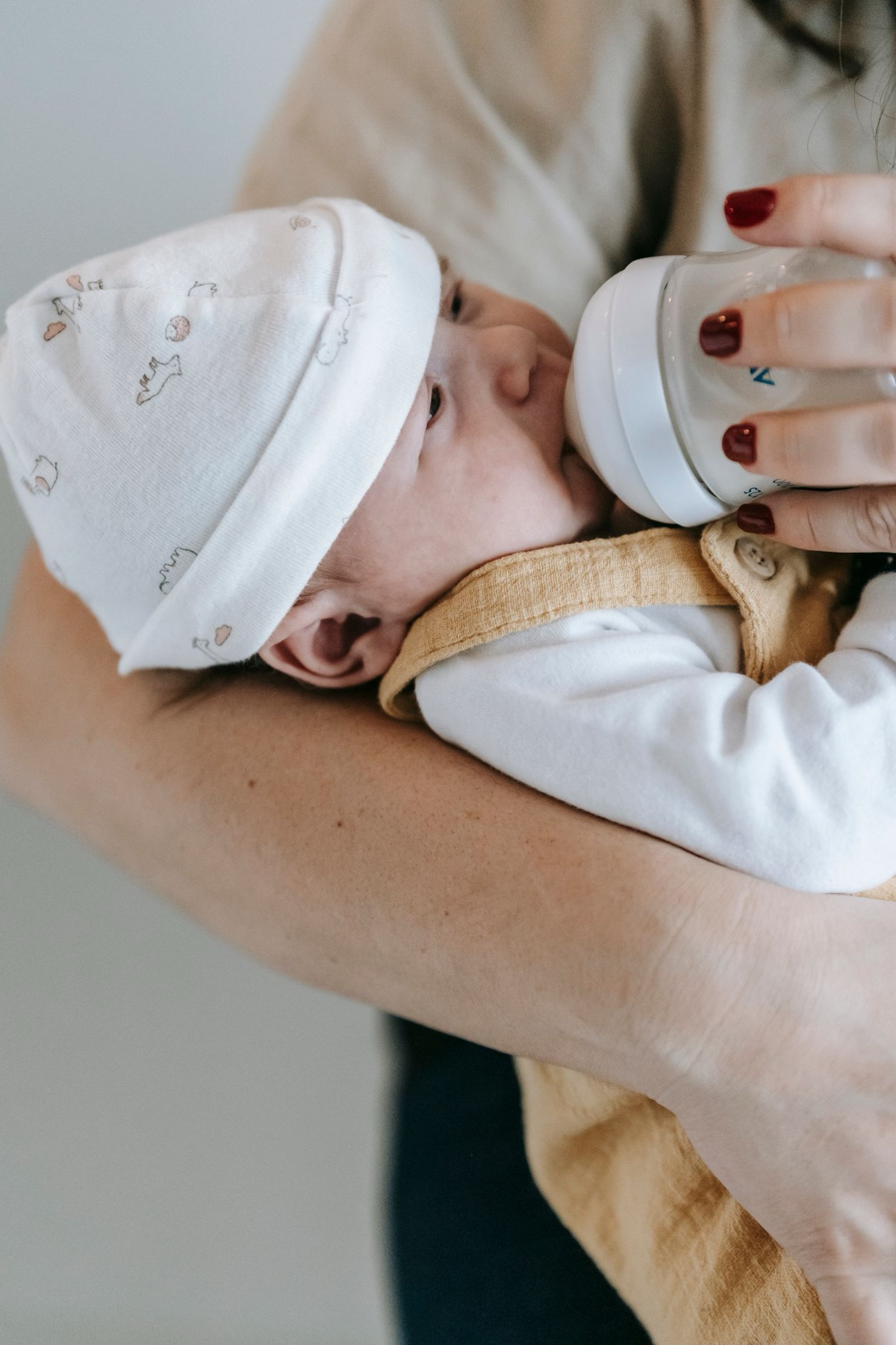 Mẹ cho bé bú bình để bù nước khi bé sốt nhẹ